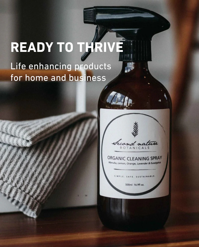 Organic cleaning spray bottle on a wooden surface with 'Second Nature Botanicals' branding.