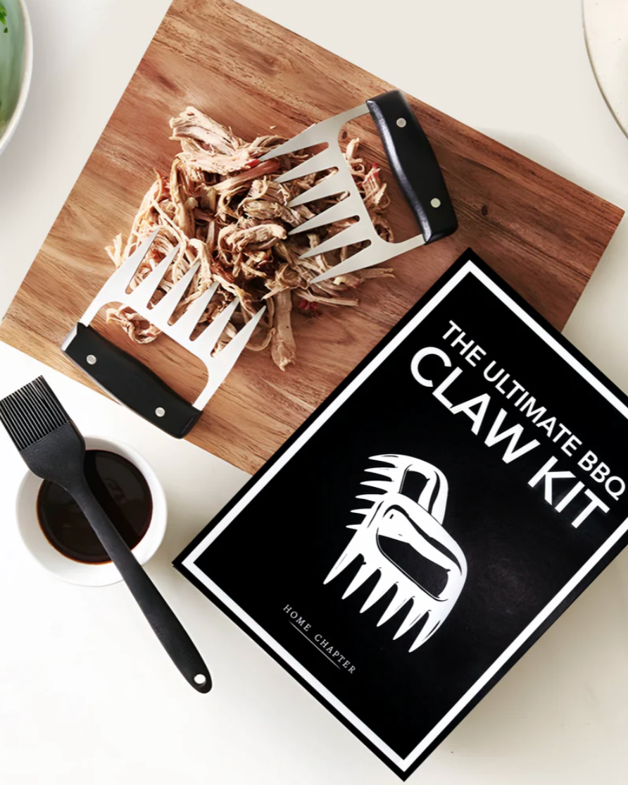 BBQ claw kit on a cutting board with a sign labeled 'The Ultimate BBQ Claw Kit' on a table.