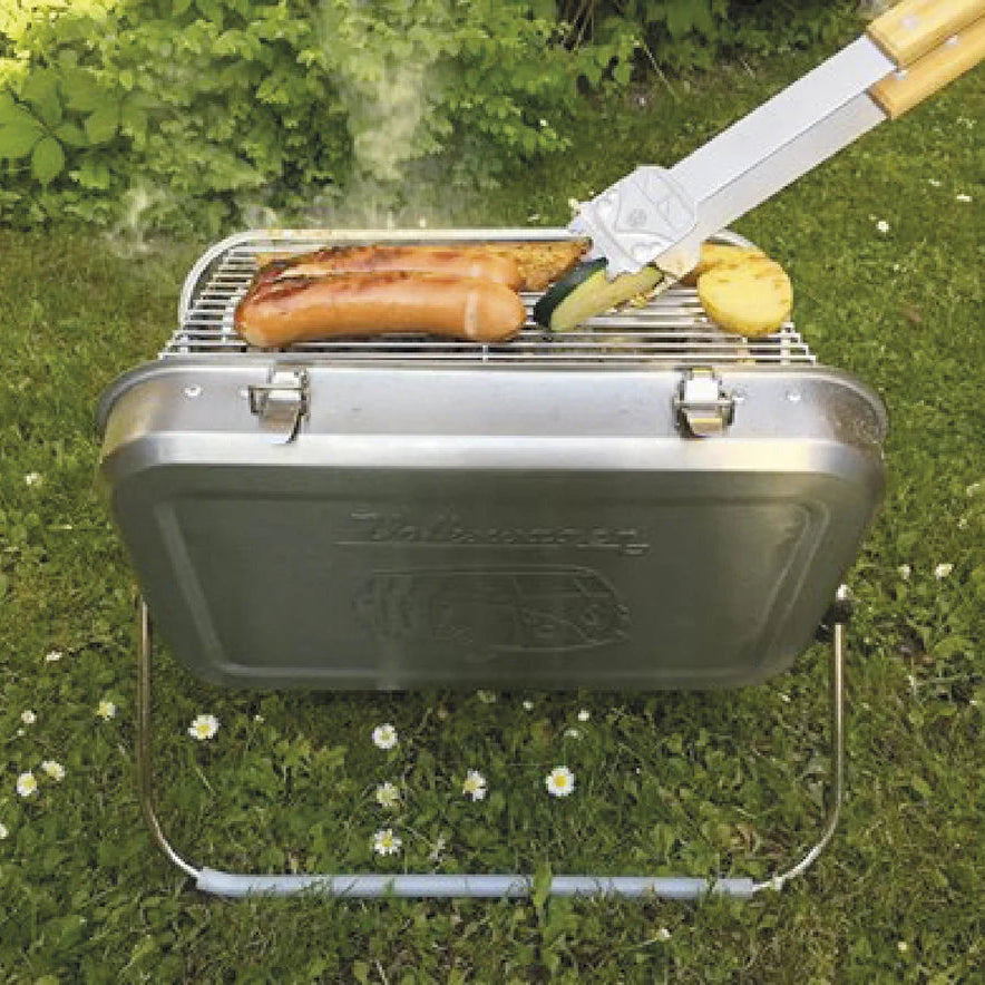Portable grill on grass with food being cooked