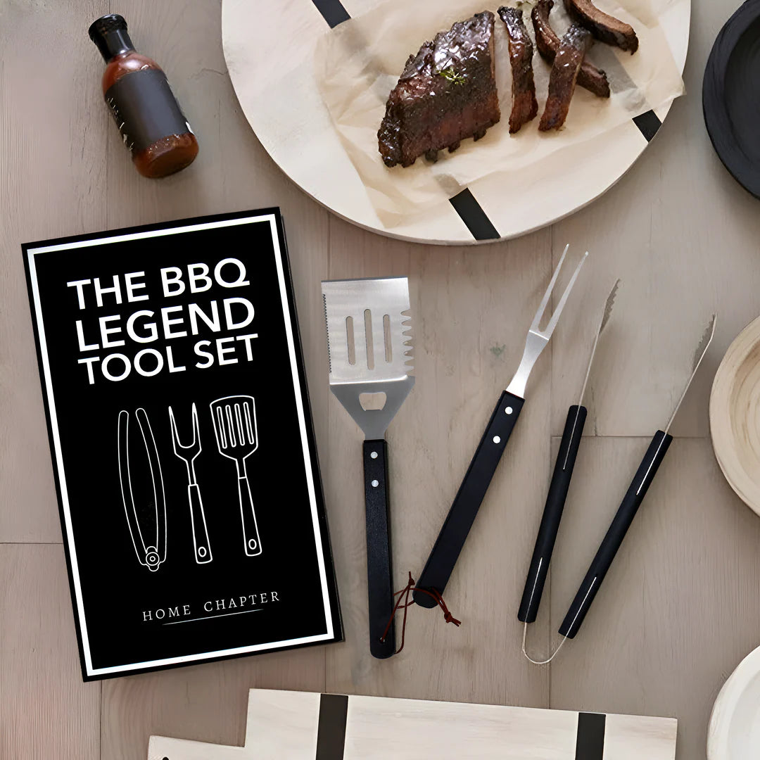 BBQ tool set with 'The BBQ Legend Tool Set' sign on a table with grilled meat.